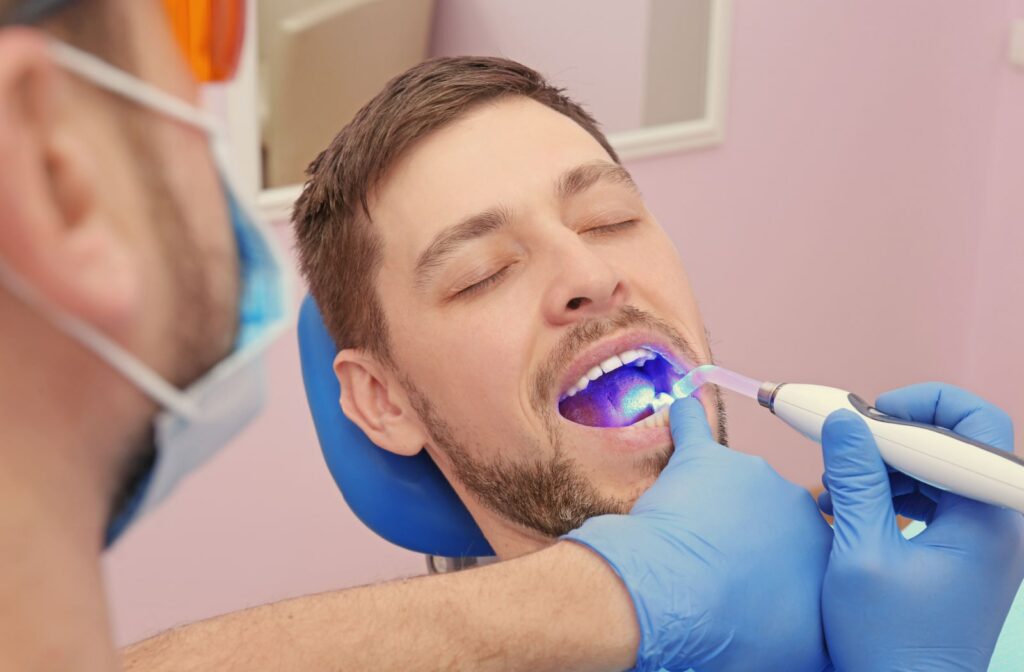 A dentist using a UV light to make the tooth filling harder